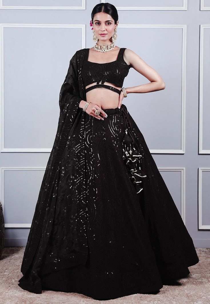 Readymade Embroidered Faux Georgette Lehenga in Black This Sleeveless attire with Cotton Lining is Enhanced with Resham and Sequins Work. Crafted in Square Neck Available with a Faux Georgette Choli and a Organza Dupatta in Black. The Choli and Lehenga Length are 12 to 15 and 42 inches respectively Do note: Accessories shown in the image are for presentation purposes only.(Slight variation in actual color vs. image is possible). We sell all kinds of Lehenga and Chaniya Choli Casual Lehenga |Sang Black Embroidered Sharara For Evening, Embroidered Black Sharara For Evening, Black Embellished Traditional Party Wear, Glamorous Embroidered Fitted Choli, Black Embellished Sets For Reception, Black Embellished Sets For Festivals, Festive Embellished Black Sets, Black Embellished Anarkali Set For Festivals, Embellished Black Anarkali Set For Festivals