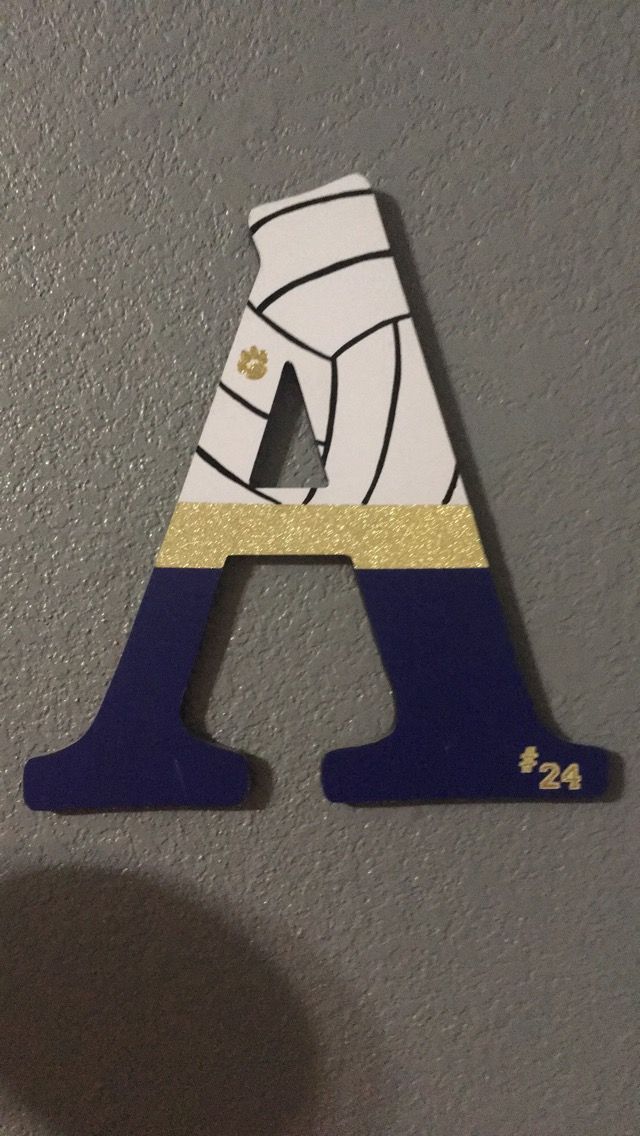 the letter a is painted in gold and blue with a volleyball uniform on it's chest