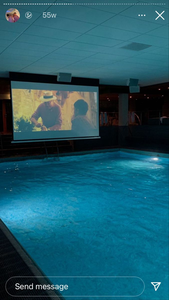 an indoor swimming pool with a projector screen