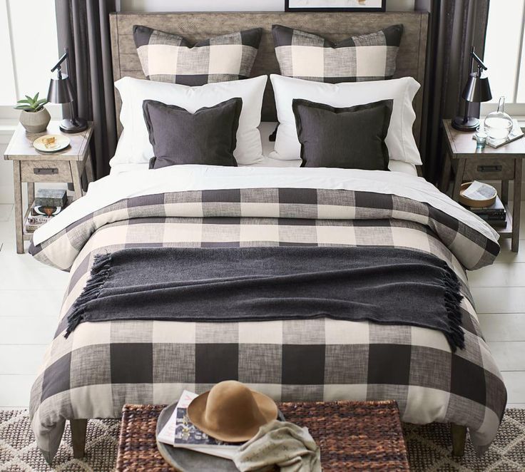 the bed is made with black and white plaid comforters, pillows, and blankets