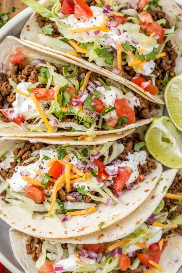 three tacos filled with ground beef, lettuce and tomatoes