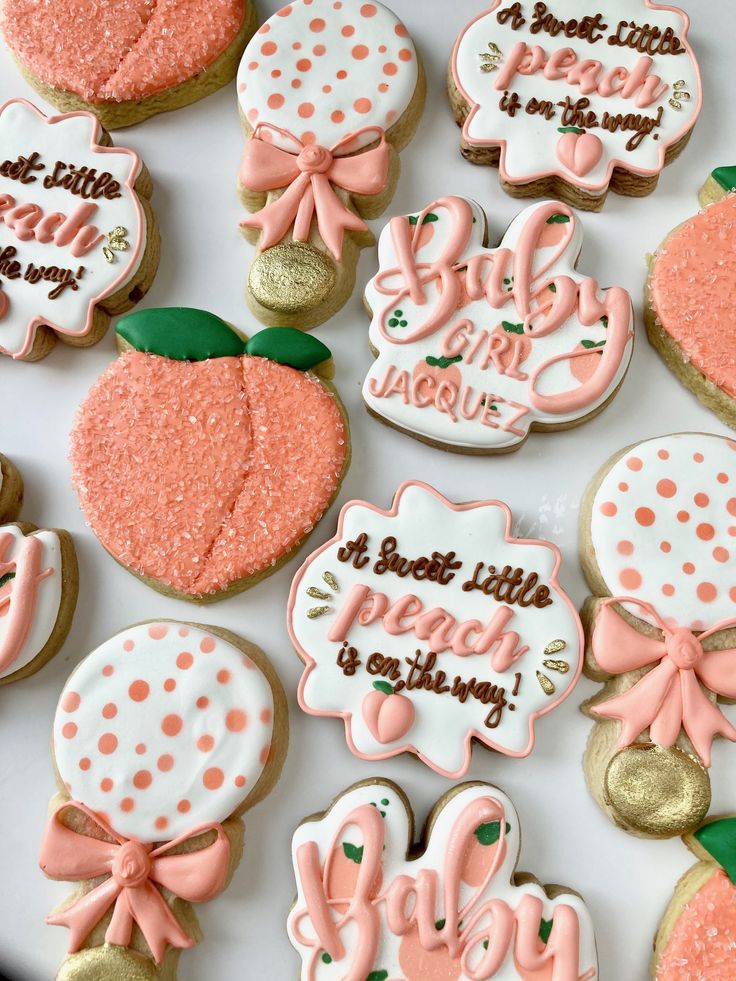 decorated cookies are arranged on a plate with pink and gold accents, such as polka dots