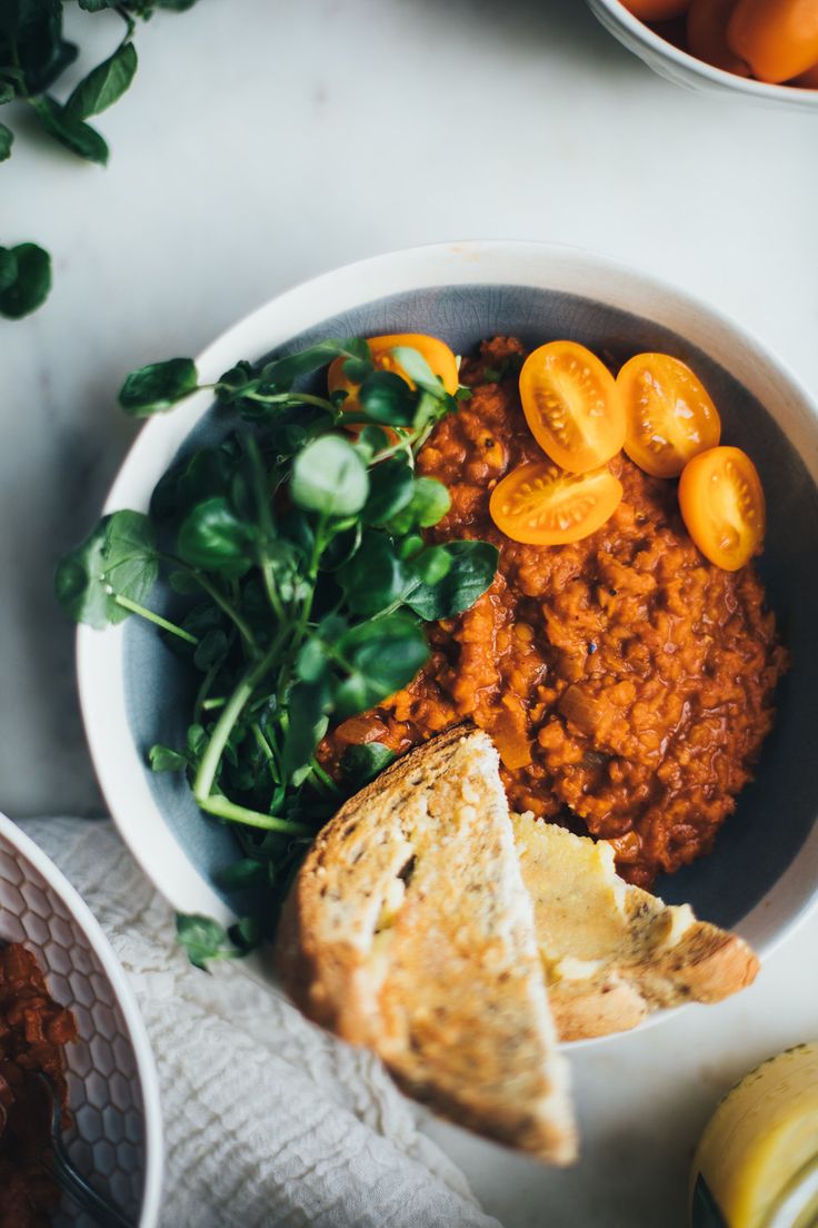 a bowl filled with beans, bread and spinach