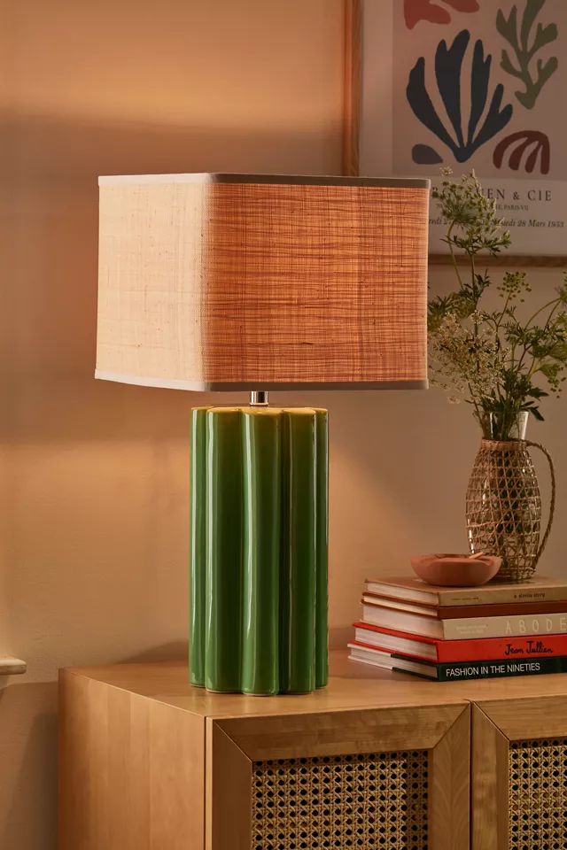 a green lamp sitting on top of a wooden table