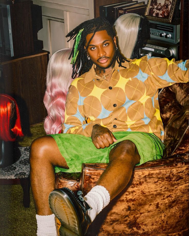 a man with dreadlocks sitting in a chair