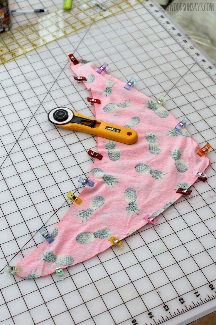 a pair of scissors sitting on top of a piece of fabric next to a ruler