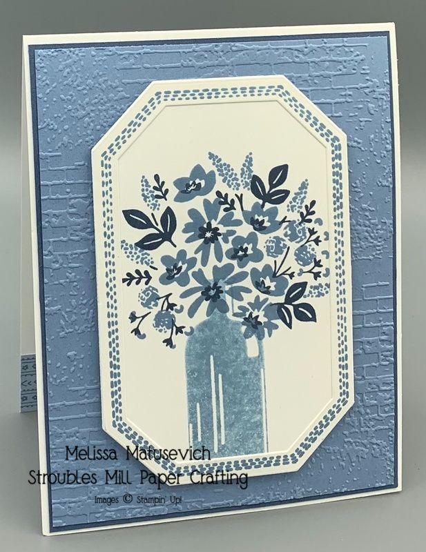 a blue and white card with flowers in the vase on it's front side