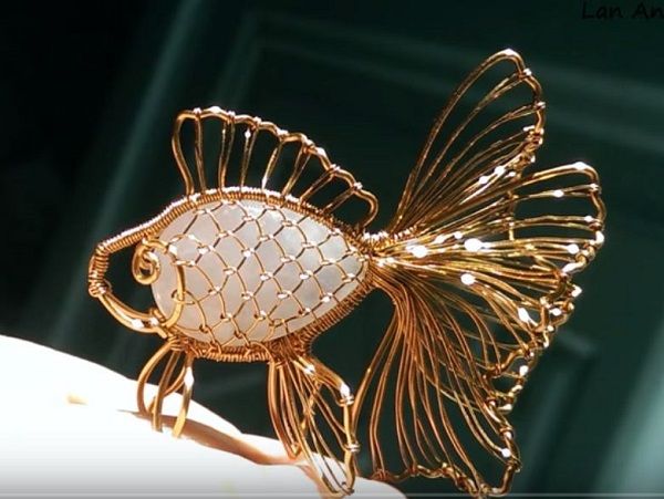 a gold fish brooch sitting on top of a table