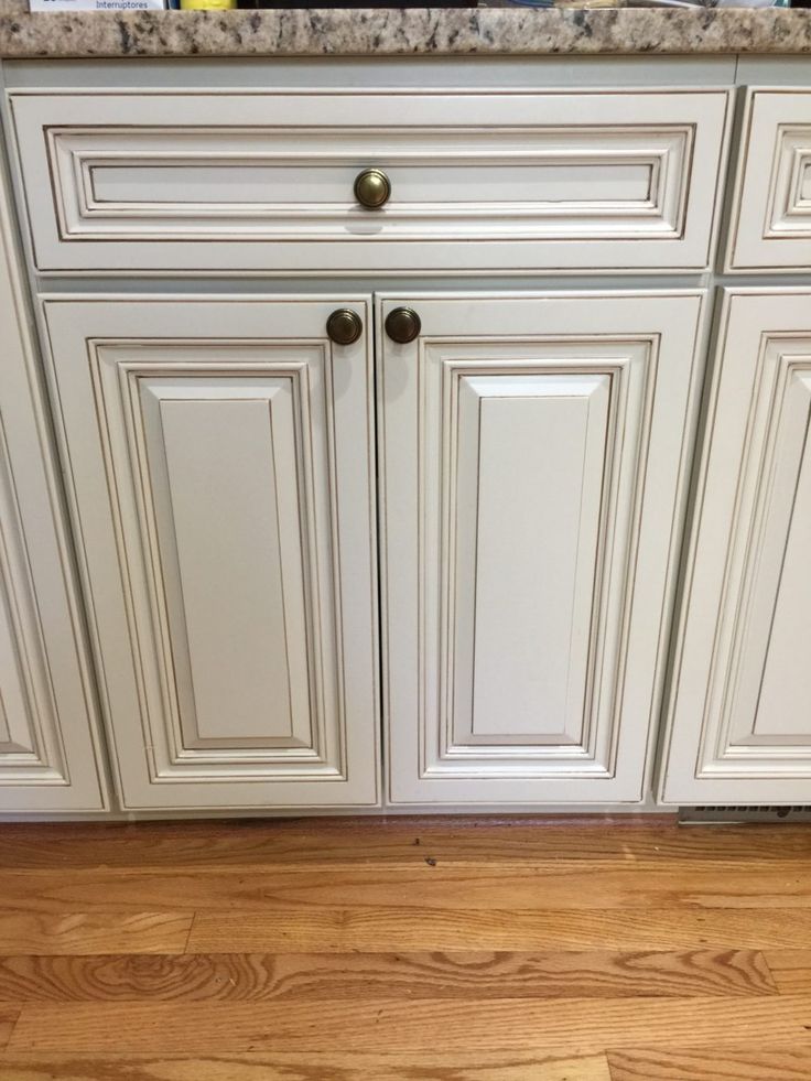 a kitchen with white cabinets and wood flooring on the side of the counter top