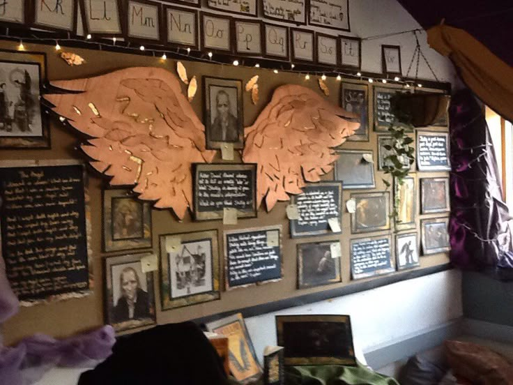 a wall covered in pictures and plaques with angel wings on it's back side