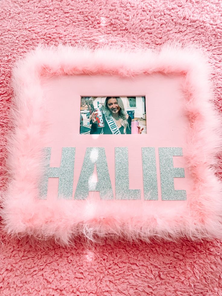 a photo frame with the word hale written on it and a pink fuzzy blanket behind it