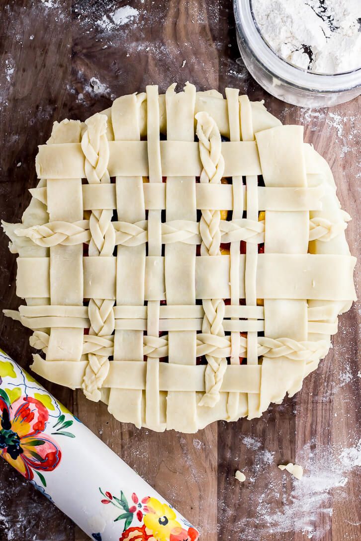 an uncooked pie sitting on top of a wooden table next to a rolling pin