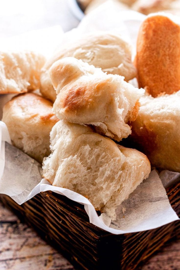 a basket filled with lots of different types of breads on top of each other