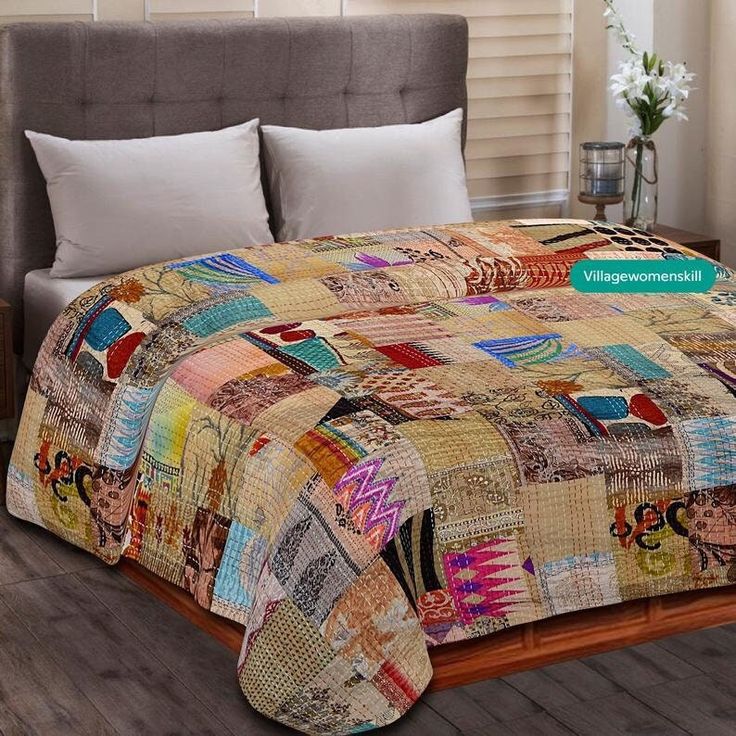 a bed covered in a multi colored patchwork quilt