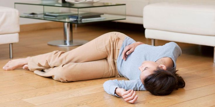 a woman laying on the floor in front of a couch