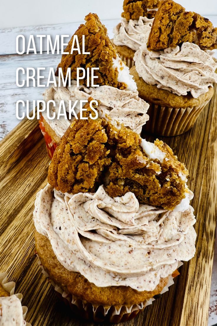 three cupcakes with white frosting on a wooden tray next to the words oatmeal cream pie cupcakes