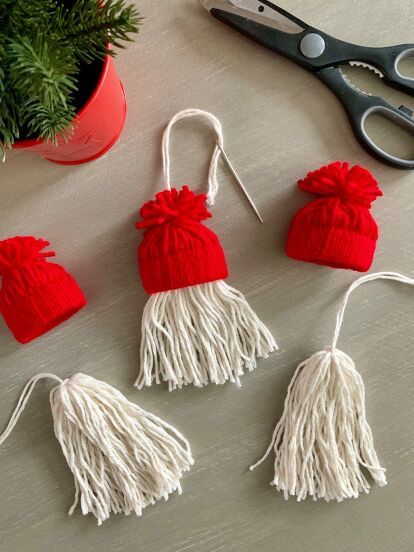 three red and white tasselled hats sitting on top of a table next to scissors