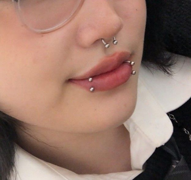 a woman wearing glasses and nose piercings