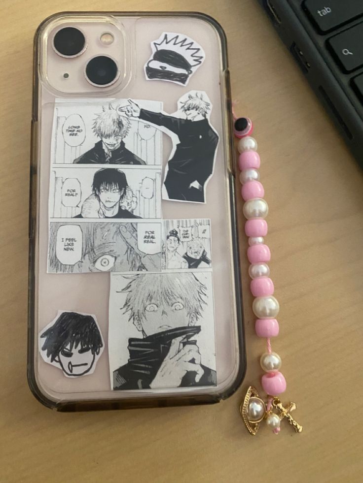 an iphone case with some stickers on it next to a keychain and keyboard