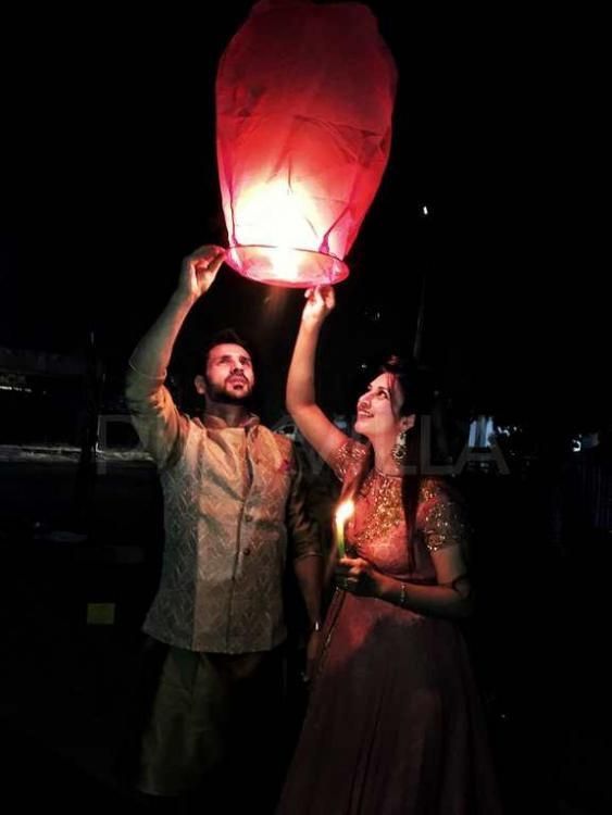 a man and woman holding up a red lantern