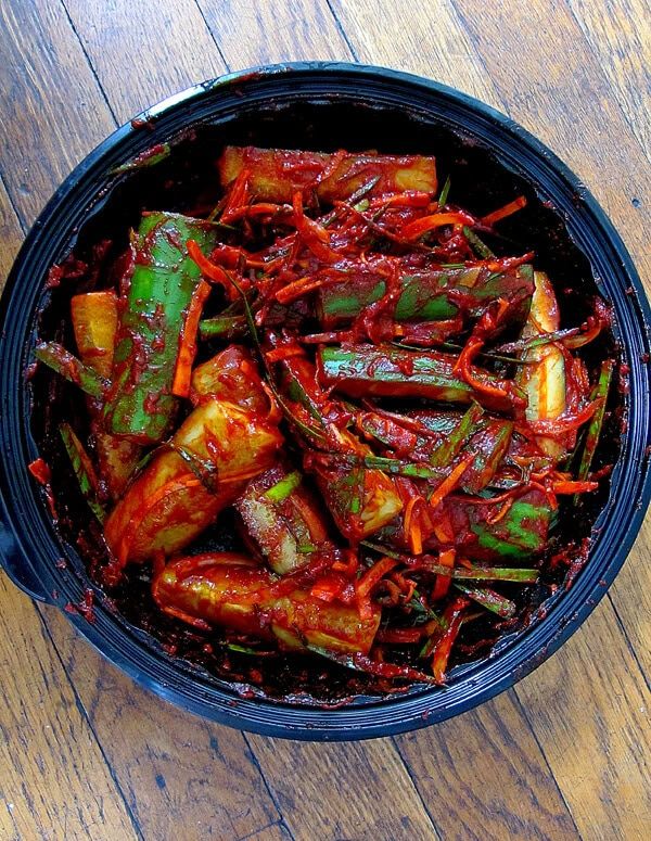 a bowl filled with cooked vegetables on top of a wooden table