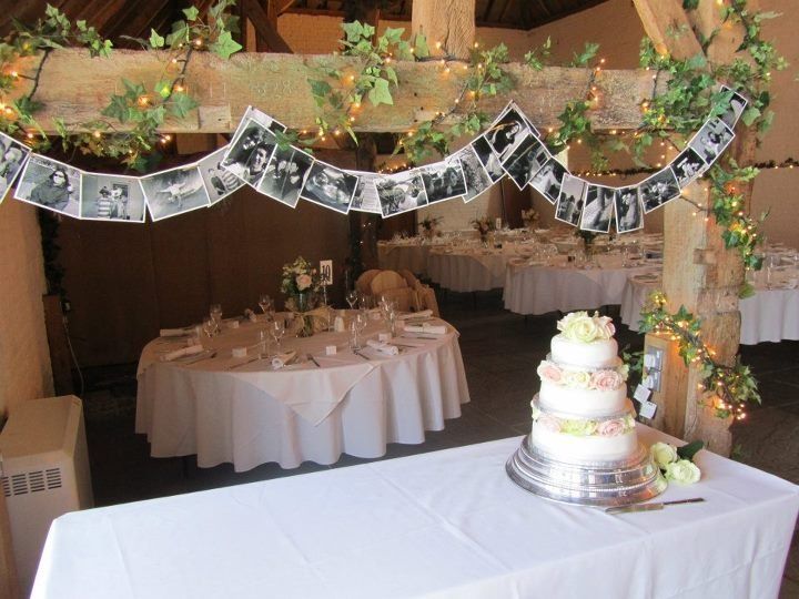 the table is set up for a wedding reception with white linens and greenery