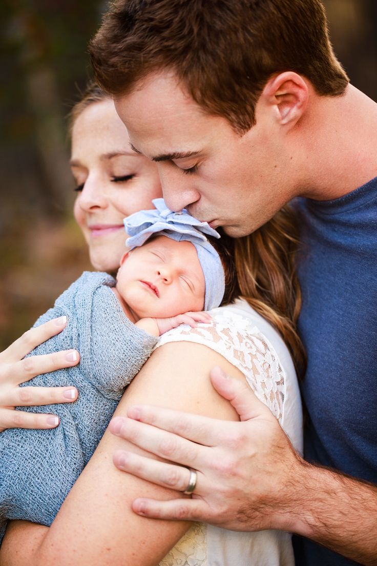 a man and woman holding a baby in their arms