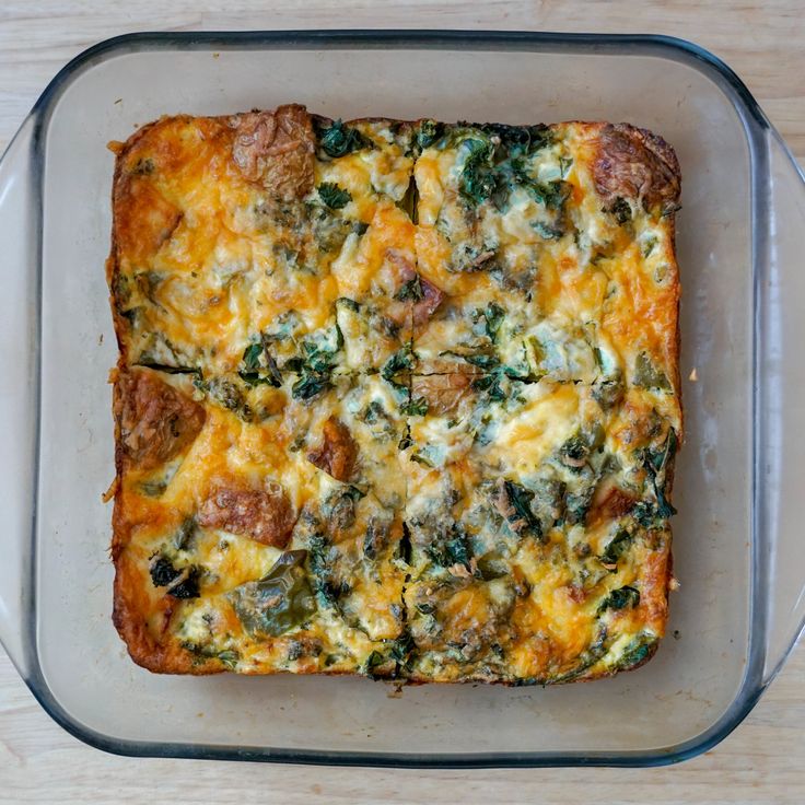 a square casserole dish with meat, cheese and spinach