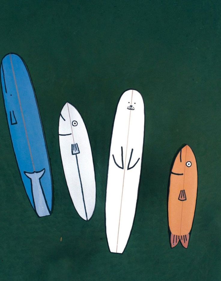 three surfboards with faces drawn on them are lined up in a row against a green background