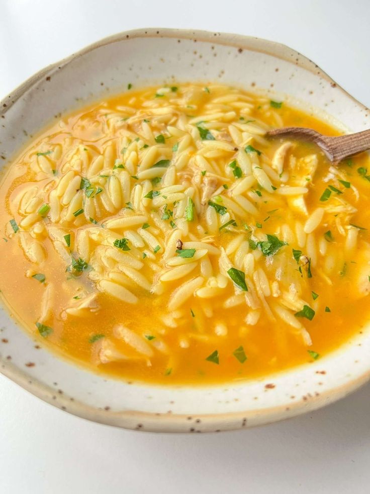 a white bowl filled with pasta and garnished with parsley