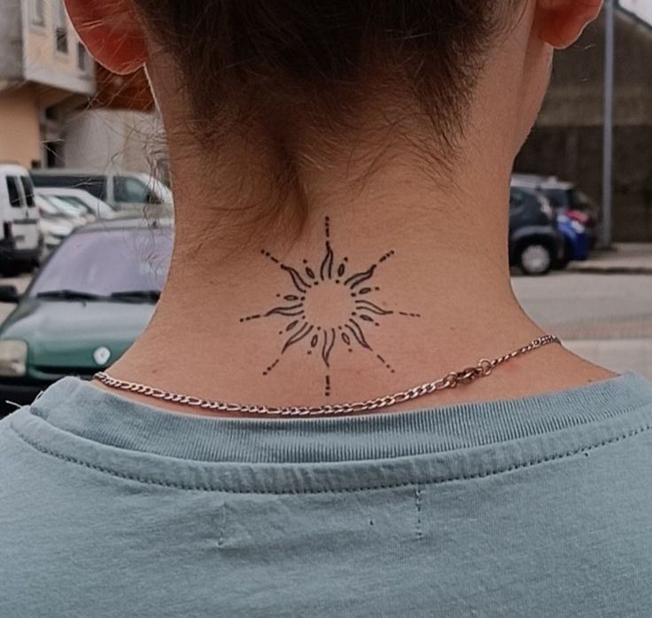 a woman with a tattoo on her neck looking at the street and parked cars behind her