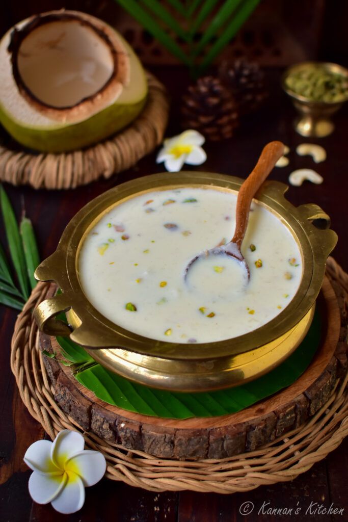 there is a bowl of soup with coconuts and flowers on the table next to it