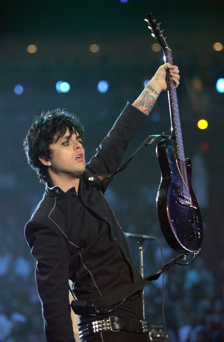 a man holding up a guitar on stage