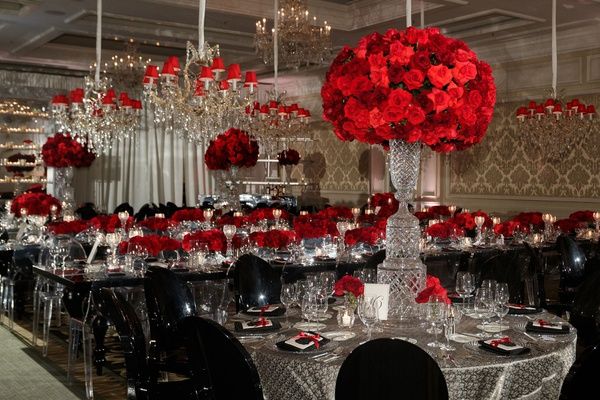 a table is set with red roses and silverware for an elegant dinner or party