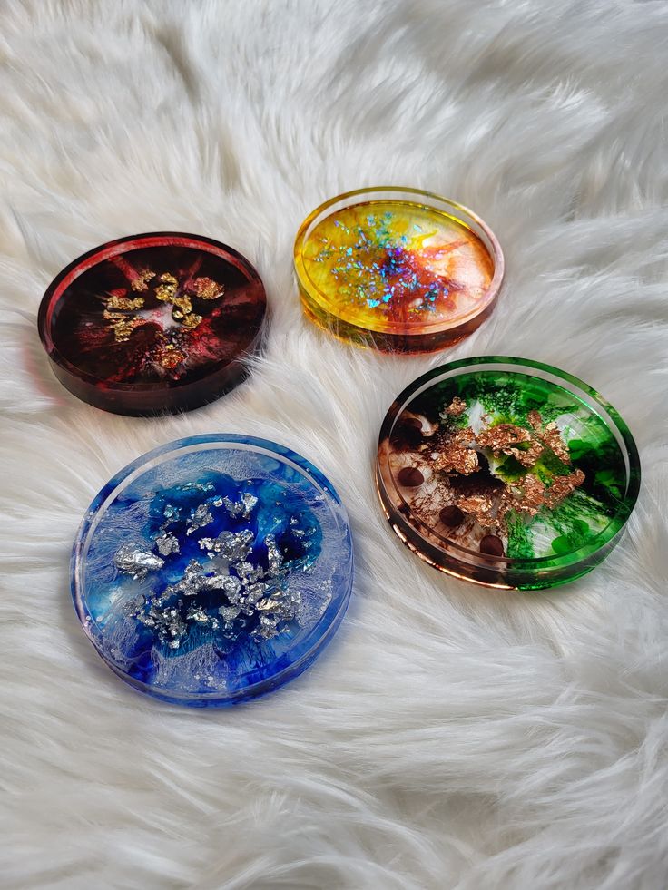 four glass plates sitting on top of a white fur covered floor