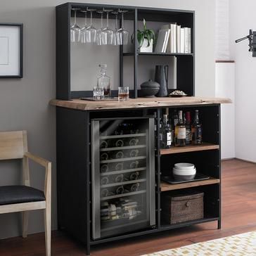 a small bar with wine glasses and bottles on it in the corner of a room