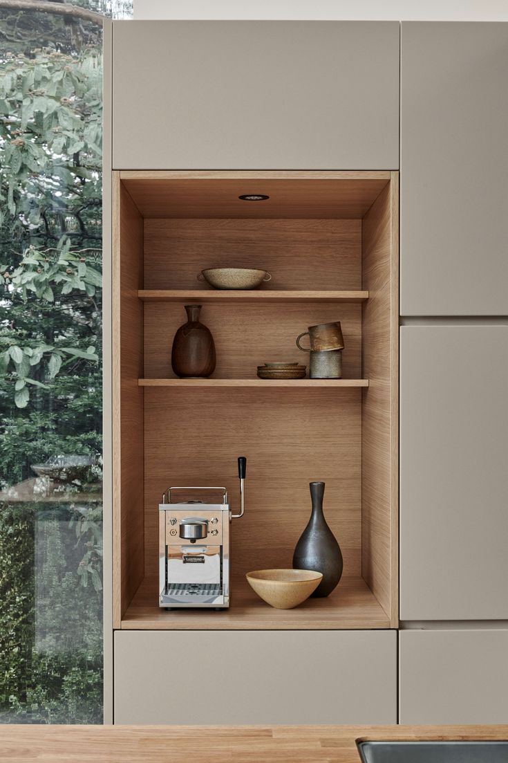 the shelves in this kitchen are filled with vases and other items, including an espresso machine