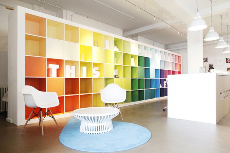 an office with multicolored bookshelves and chairs