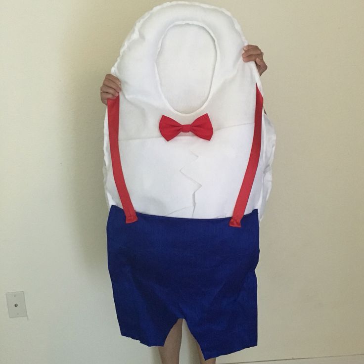 a person wearing a white shirt and blue shorts with a red bow tie on his head