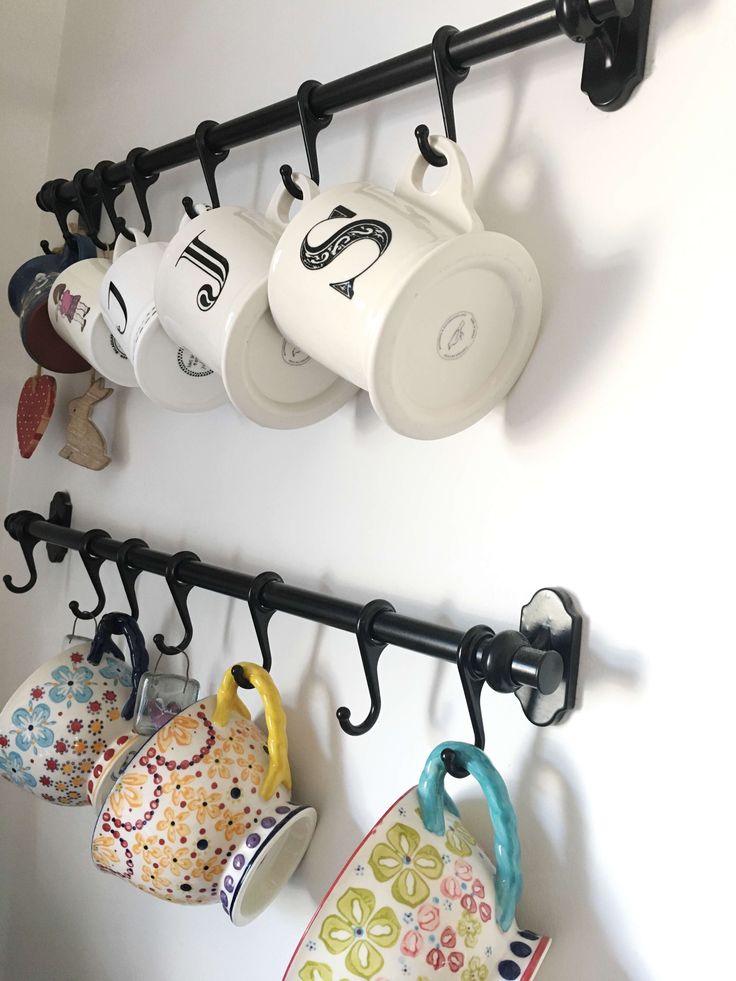 coffee mugs are hanging on the wall next to cups