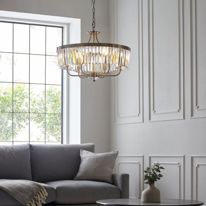 a living room filled with furniture and a chandelier hanging over the top of it