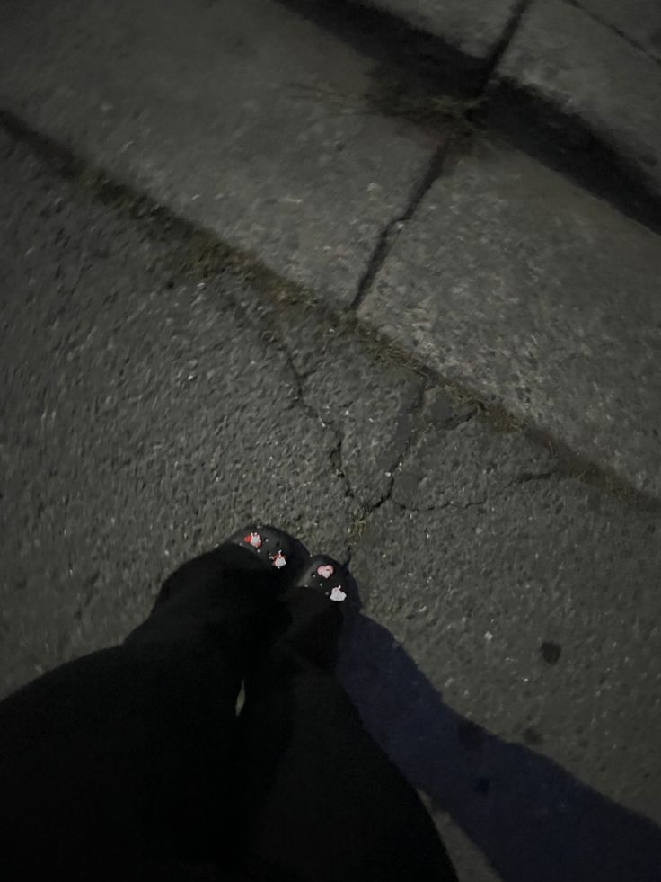 a person standing on the street with their feet up