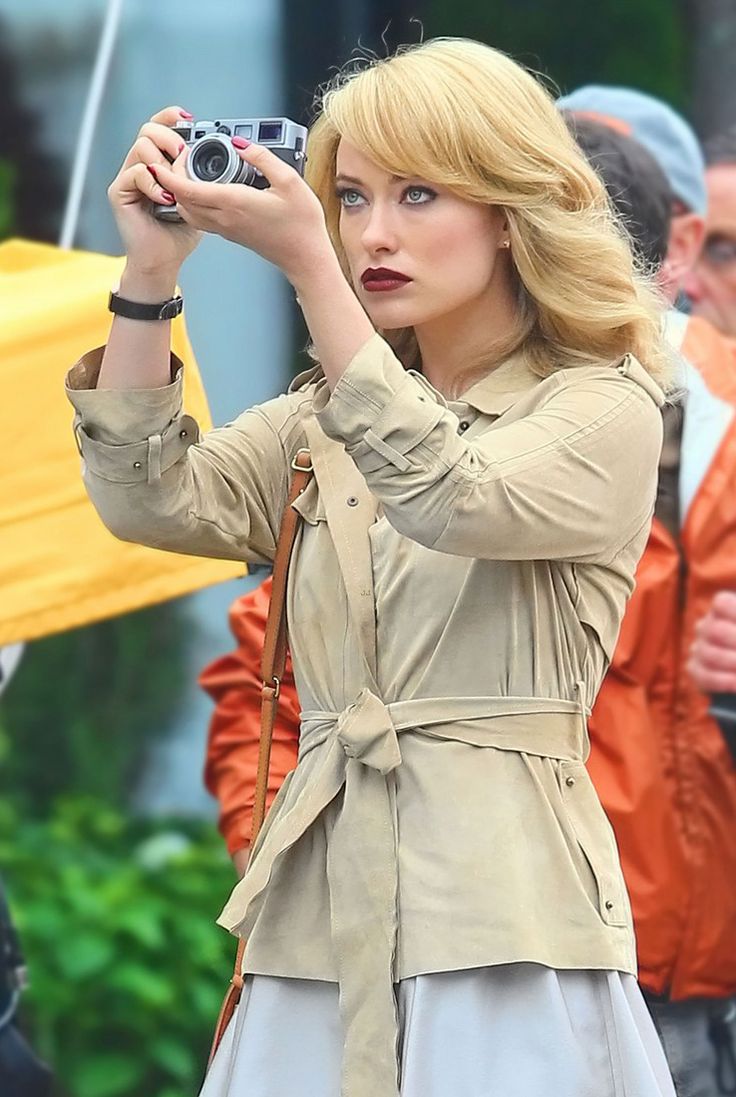 a woman holding a camera up to take a picture in front of some other people