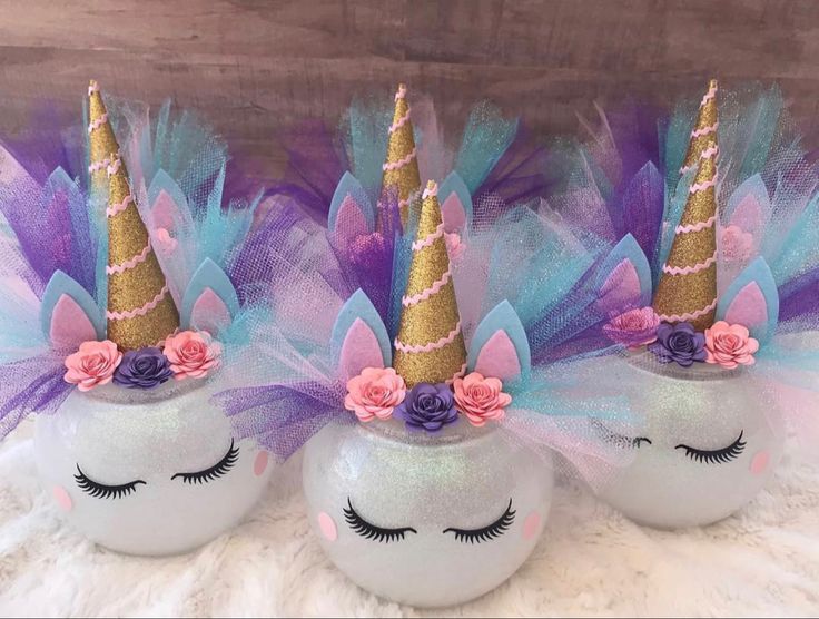 three unicorn - like balls with purple and blue hair