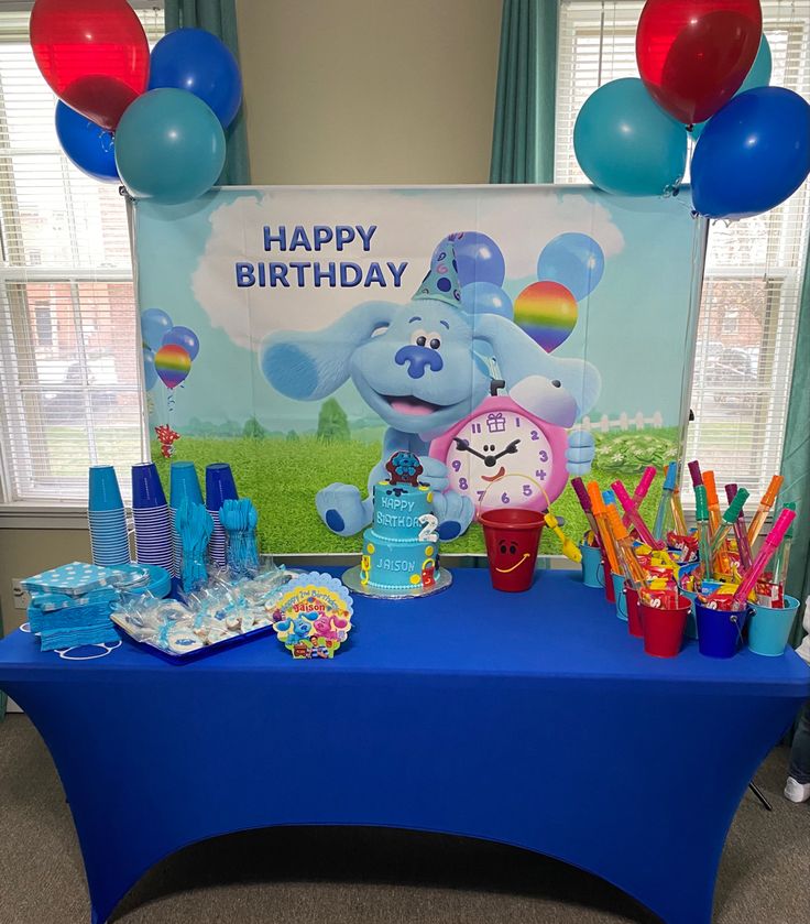 a blue table topped with lots of balloons