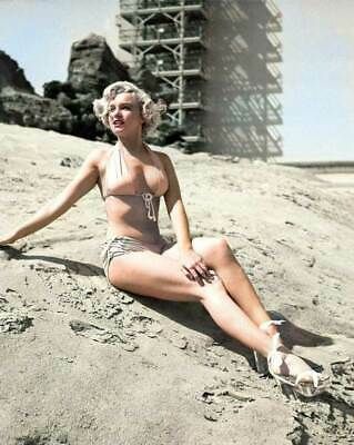 a woman in a bathing suit sitting on the beach