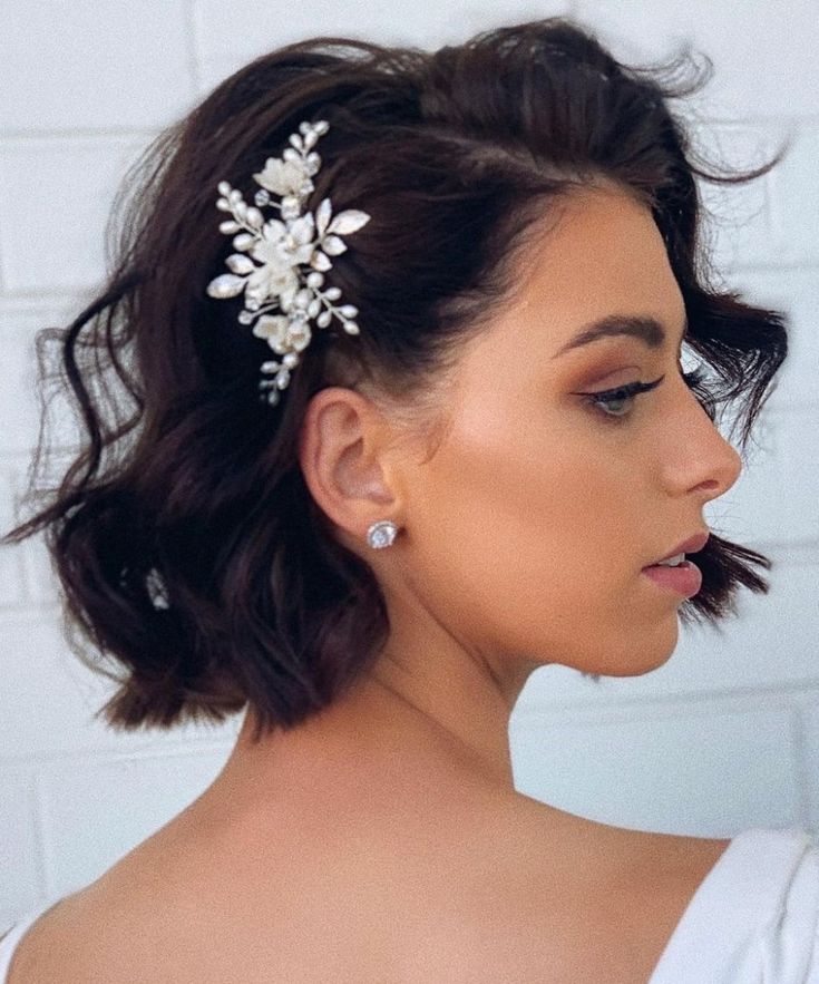 a woman wearing a white dress with a hair comb in her hair and earrings on her head