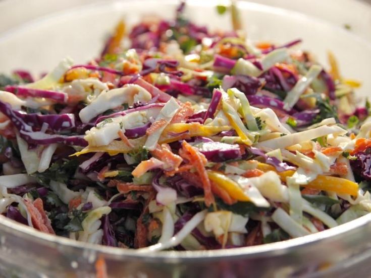 a glass bowl filled with coleslaw and carrots