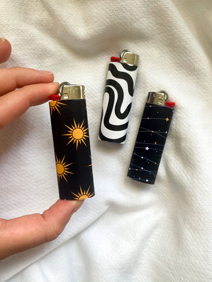 two lighters in the shape of sun and moon are being held by someone's hand