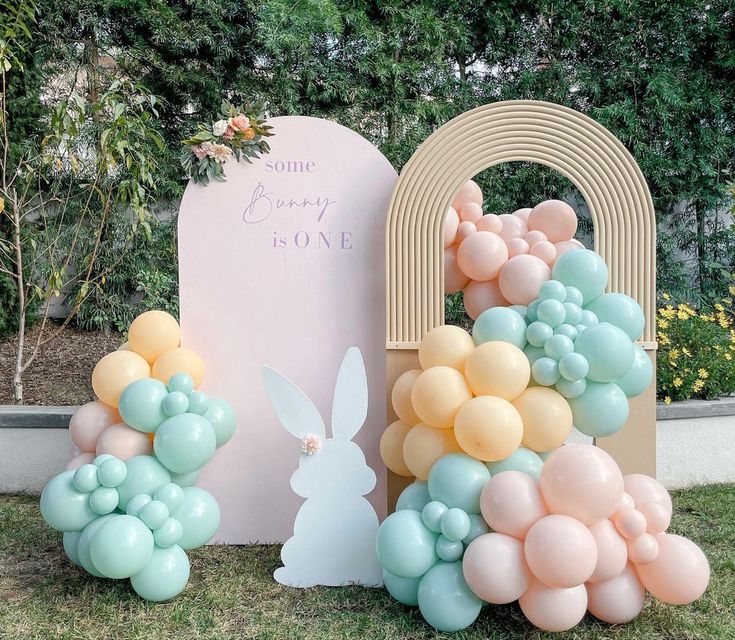 some balloons are in the shape of bunnies and an easter bunny is standing next to it